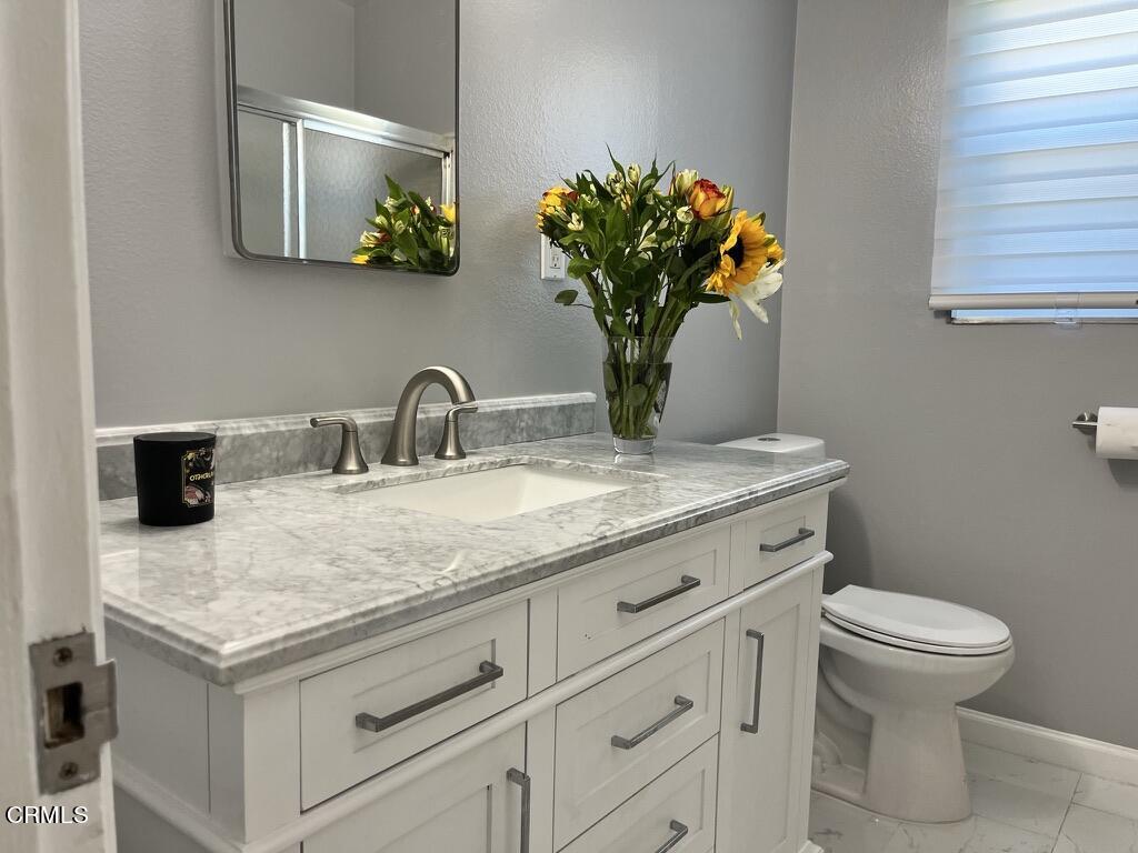 517 View Crest Drive Montebello, CA 90640 - Photo 16 of 21 a bathroom with a granite countertop toilet sink and mirror