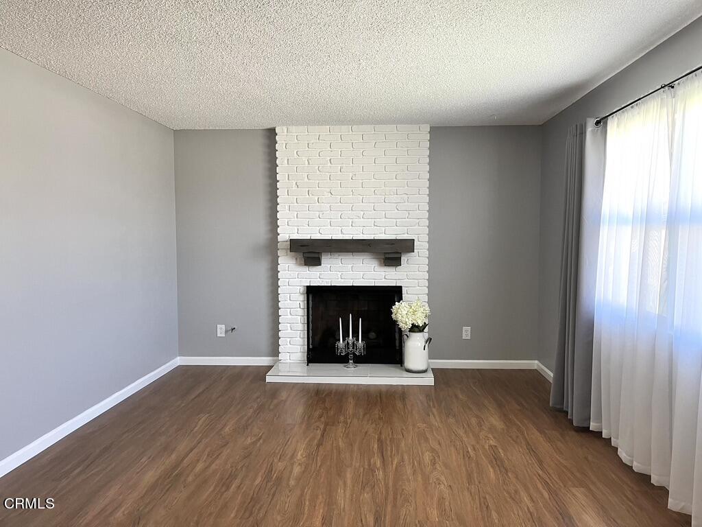 517 View Crest Drive Montebello, CA 90640 - Photo 3 of 21 a view of an empty room with wooden floor fireplace and a window