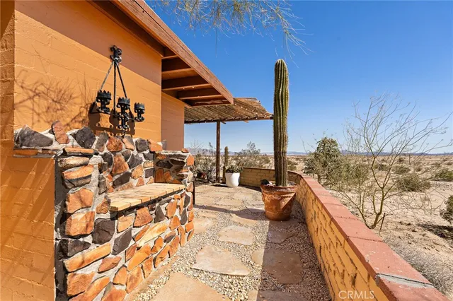 a view of a balcony with chairs and iron fence