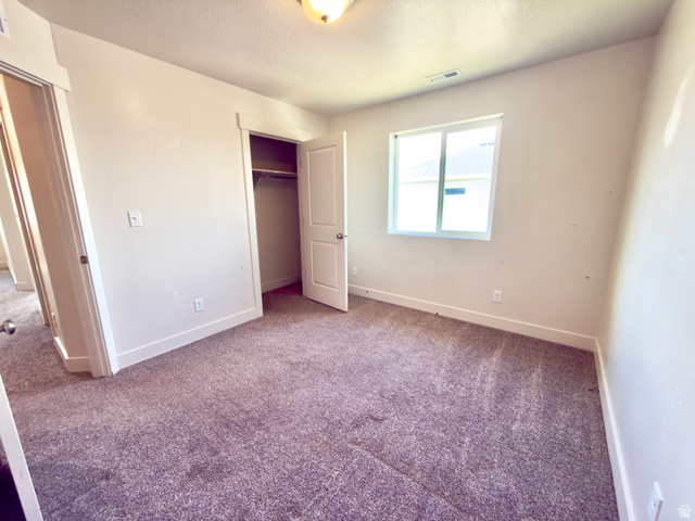 1823 South Longview Road Santaquin, UT 84655 - Photo 41 of 69 Carpeted interior space featuring a window with white trim, a recessed closet, and a ceiling-mounted light fixture