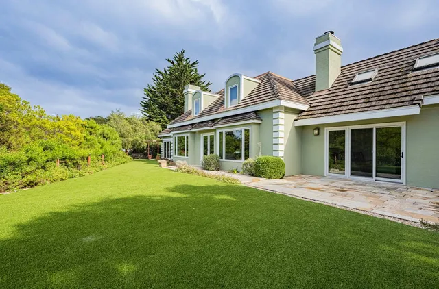 a living room with furniture and a large window with wooden floor