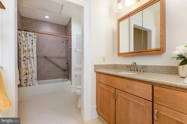 a view of a hallway with wooden floor and a bathroom