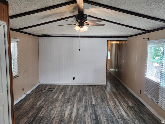 332 Joshua Street Tooele, UT 84074 - Photo 10 of 16 Spacious interior featuring wood-finish flooring, a vaulted ceiling with exposed beams, and a ceiling fan with integrated lighting