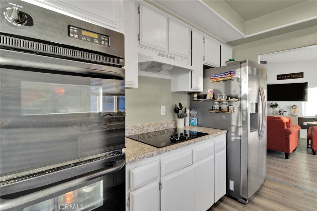 13167 Olathe Road Apple Valley, CA 92308 - Photo 18 of 40 a kitchen with stainless steel appliances kitchen island granite countertop a stove and a refrigerator