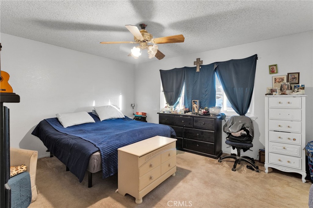 13167 Olathe Road Apple Valley, CA 92308 - Photo 27 of 40 a bedroom with a bed and a chandelier