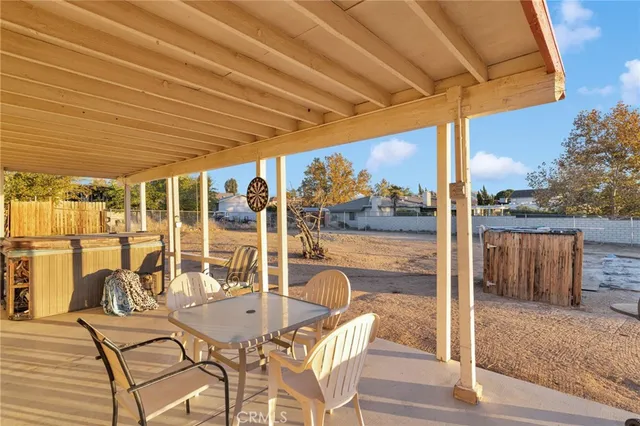 a view of a patio with a table chairs and wooden floor