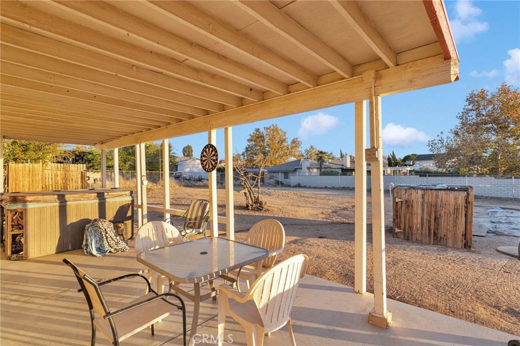 13167 Olathe Road Apple Valley, CA 92308 - Photo 33 of 40 a view of a patio with a table chairs and wooden floor