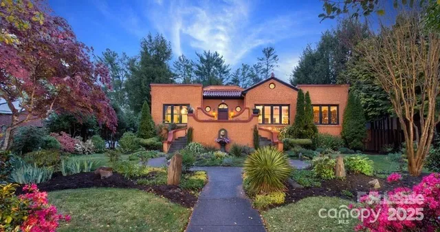 a front view of a house with a yard and potted plants
