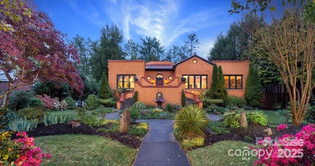 a front view of a house with a yard and potted plants