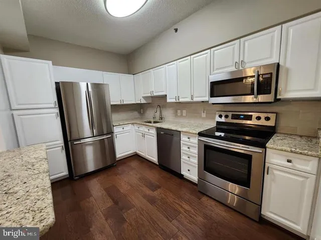 a kitchen with stainless steel appliances a stove a microwave and a refrigerator