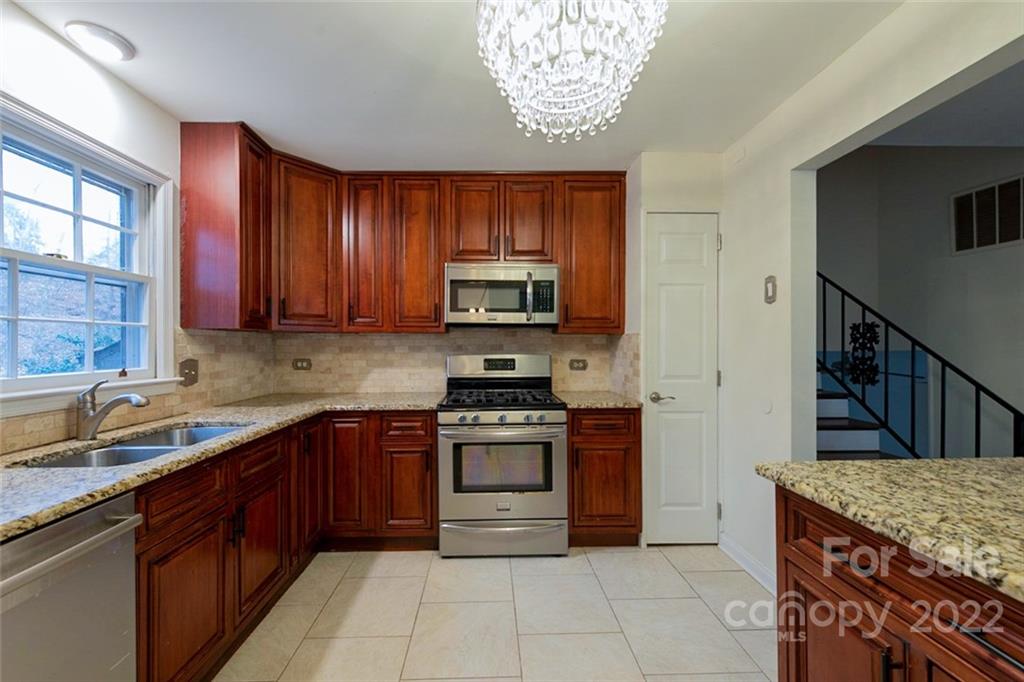 2522 Merrywood Road Charlotte, NC 28210 - Photo 4 of 21 a kitchen with stainless steel appliances granite countertop a sink dishwasher stove and oven with wooden cabinets
