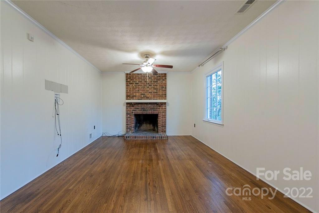 2522 Merrywood Road Charlotte, NC 28210 - Photo 5 of 21 a view of empty room with wooden floor and fireplace