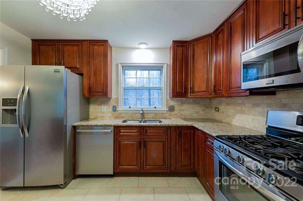 2522 Merrywood Road Charlotte, NC 28210 - Photo 8 of 21 a kitchen with stainless steel appliances granite countertop a stove top oven a refrigerator and a microwave