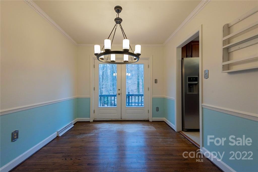 2522 Merrywood Road Charlotte, NC 28210 - Photo 9 of 21 an empty room with wooden floor and chandelier