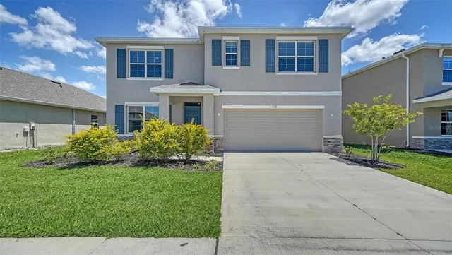 a front view of a house with a yard and garage