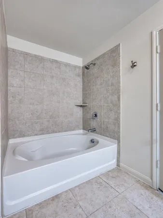 a white bath tub sitting next to a shower