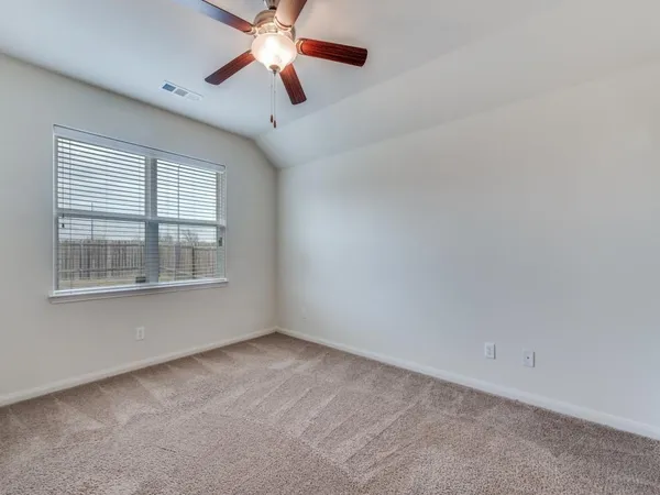 an empty room with a window and a fan