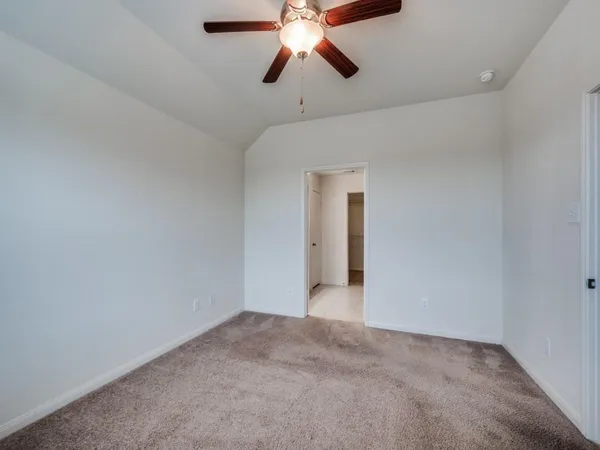 a view of an empty room and chandelier fan