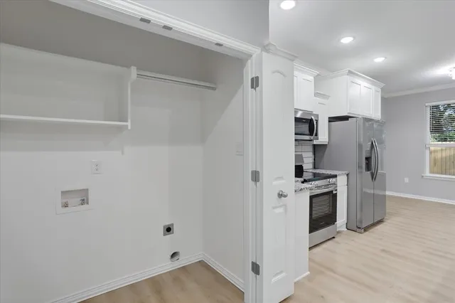 a kitchen with white cabinets and stainless steel appliances
