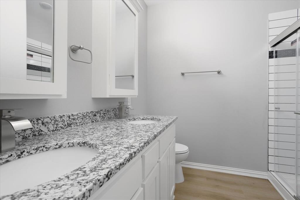 215 East Nelson Street Denison, TX 75021 - Photo 16 of 27 a bathroom with a granite countertop sink and a toilet