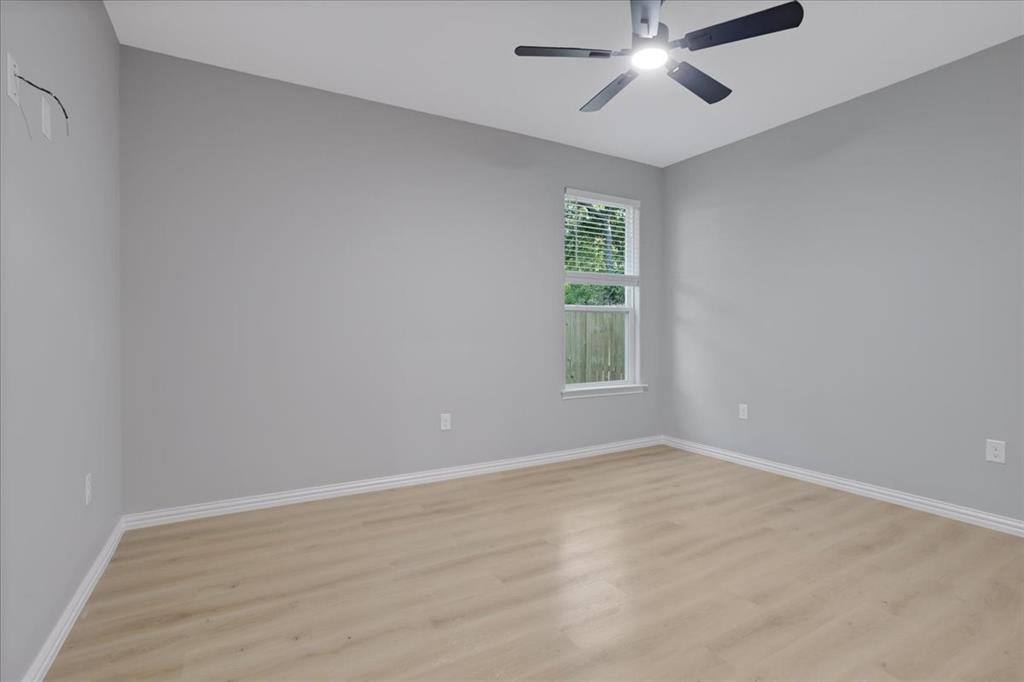 215 East Nelson Street Denison, TX 75021 - Photo 21 of 27 an empty room with windows and fan