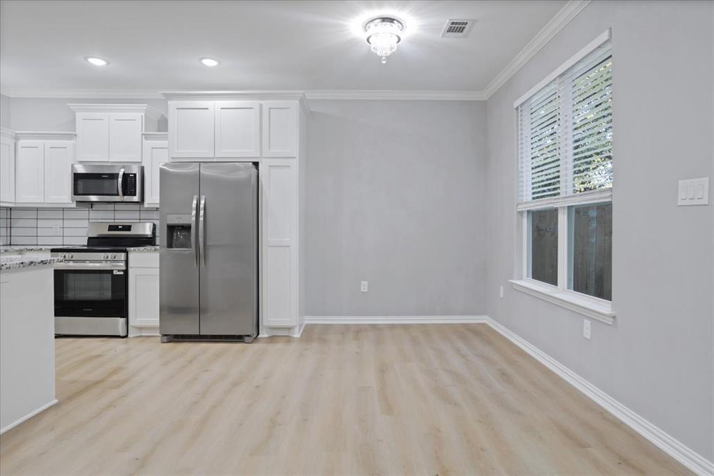 215 East Nelson Street Denison, TX 75021 - Photo 4 of 27 a view of a kitchen with a sink and a refrigerator