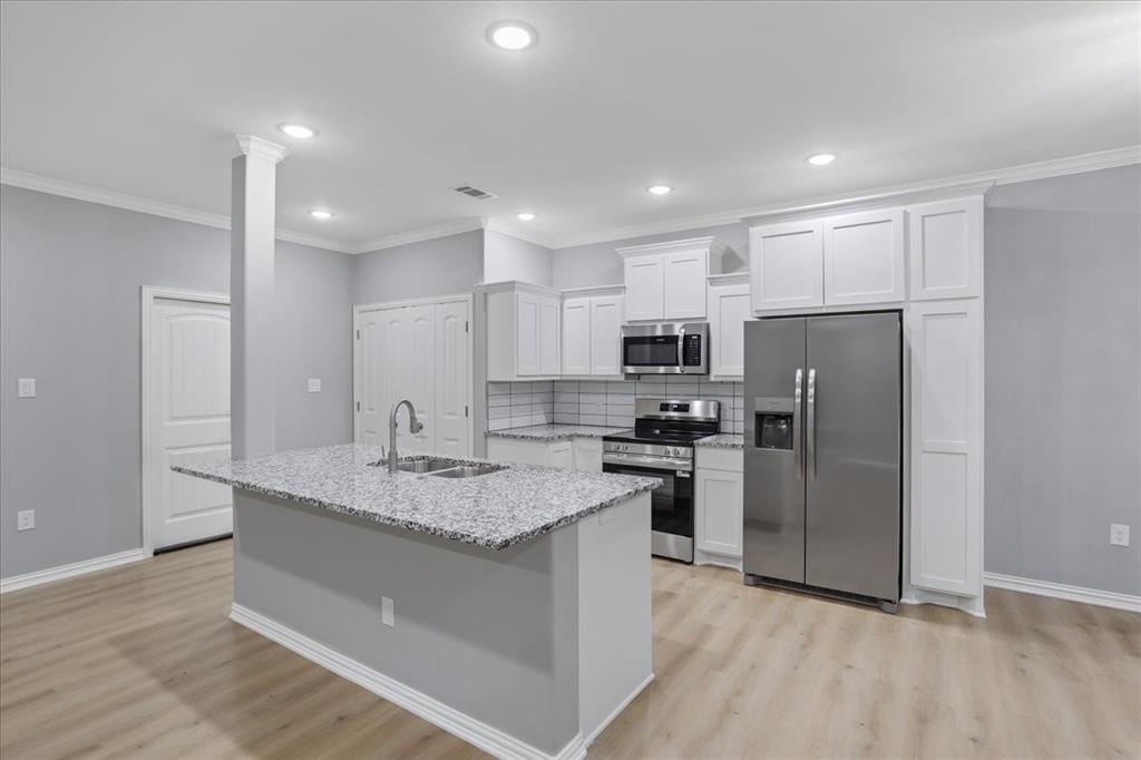 215 East Nelson Street Denison, TX 75021 - Photo 5 of 27 a kitchen with stainless steel appliances granite countertop a refrigerator a stove a sink and a microwave