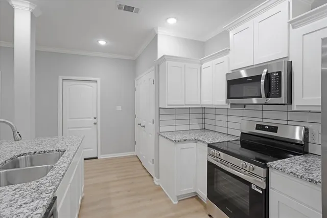 a kitchen with a sink stove and microwave