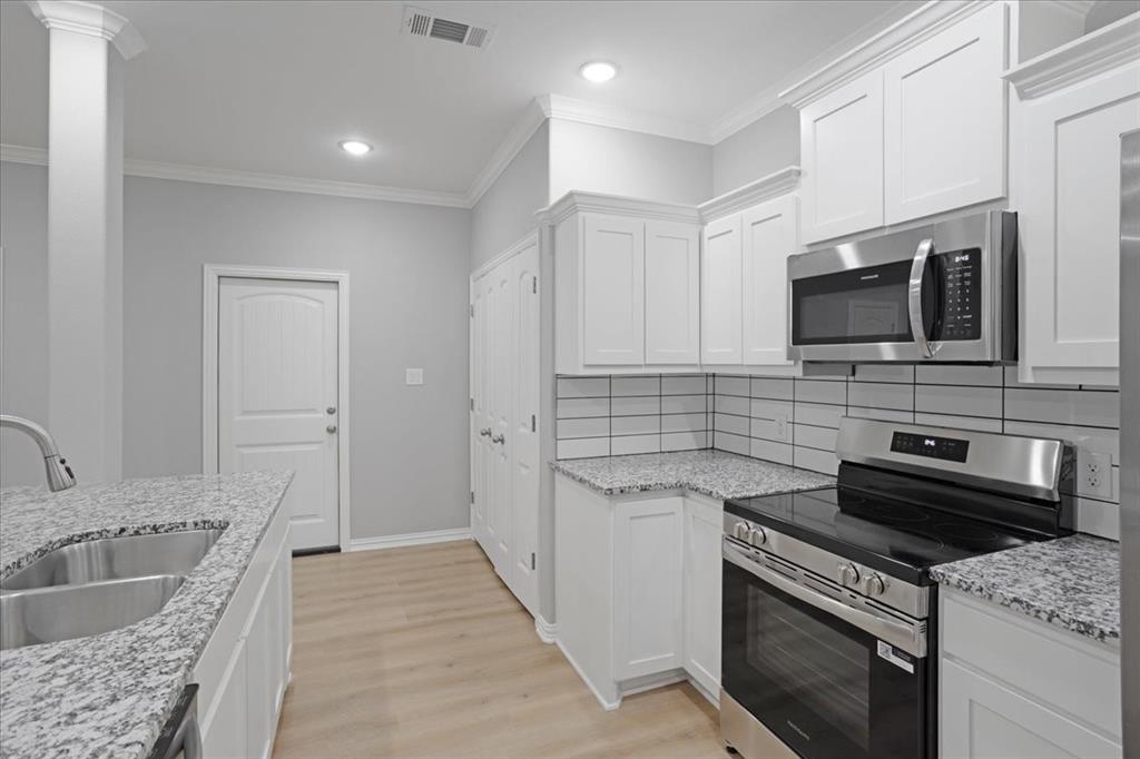 215 East Nelson Street Denison, TX 75021 - Photo 6 of 27 a kitchen with a sink stove and microwave