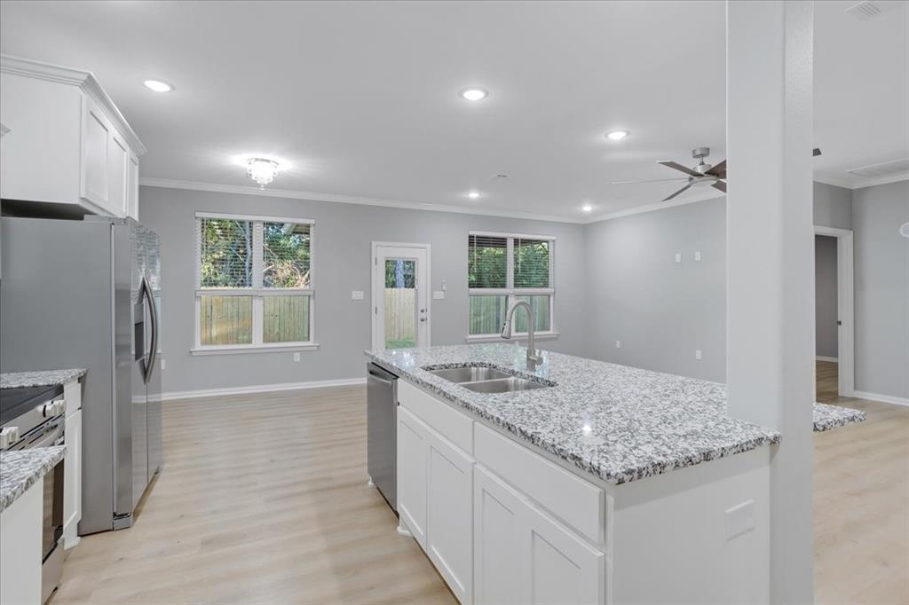 215 East Nelson Street Denison, TX 75021 - Photo 7 of 27 a kitchen with a stove a refrigerator and countertop