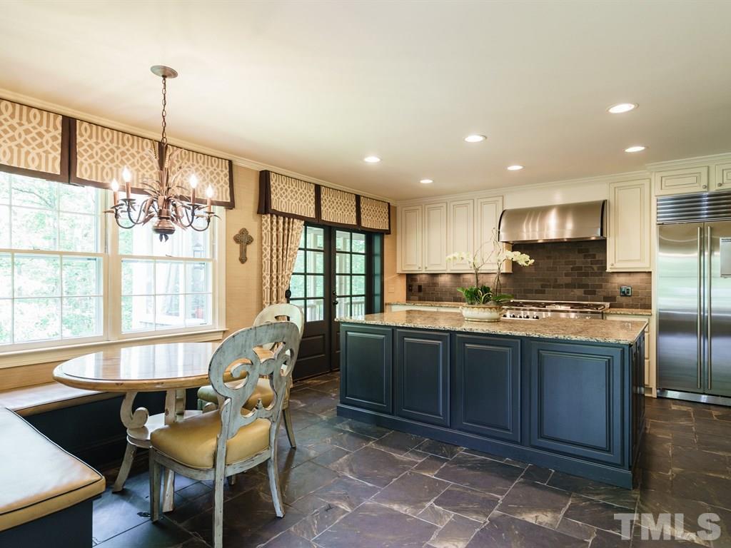 3116 Eton Road Raleigh, NC 27608 - Photo 8 of 25 a kitchen with granite countertop a refrigerator a stove a sink dishwasher with a dining table and chairs