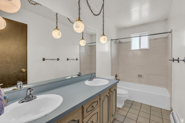 10705 Green Ridge Drive Sandy, UT 84070 - Photo 22 of 55 Bathroom with double vanity, light tile patterned floors, tub / shower combination, and a baseboard radiator