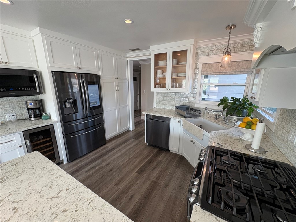 15471 Victoria Huntington Beach, CA 92647 - Photo 6 of 37 a kitchen with stainless steel appliances a stove a sink and a refrigerator
