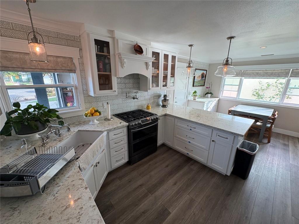 15471 Victoria Huntington Beach, CA 92647 - Photo 7 of 37 a kitchen with stainless steel appliances sink stove refrigerator and wooden floor