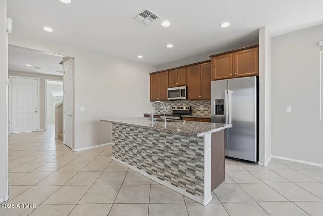 an empty room with chandelier fan and window