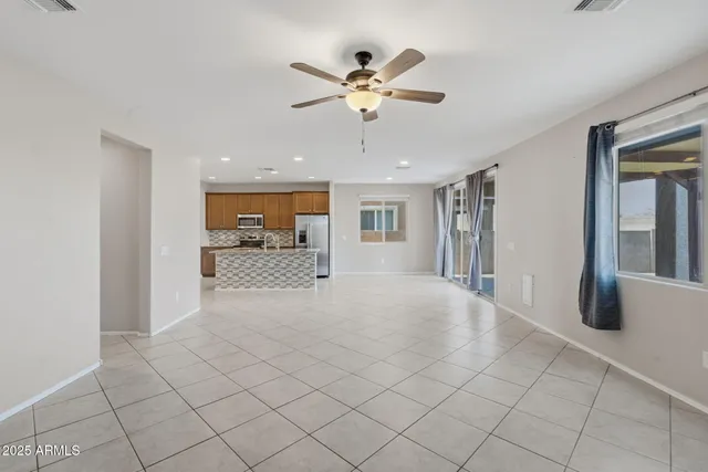 an empty room with a window and a fan