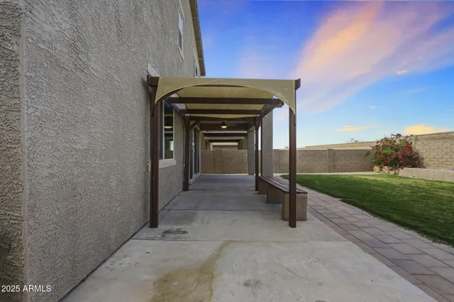 a view of swimming pool with lawn chairs and large trees