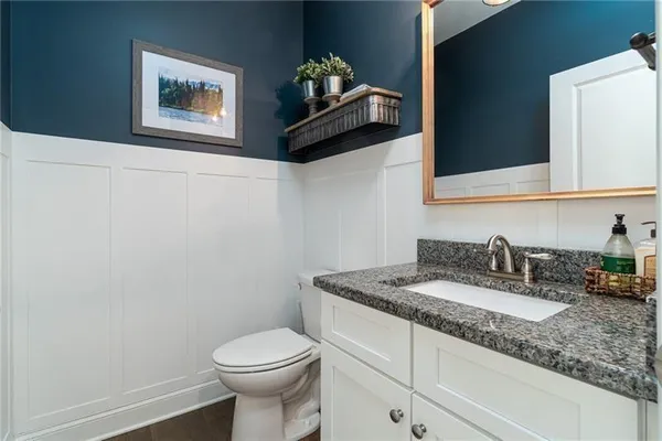 a bathroom with a toilet a sink and mirror