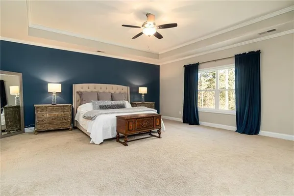 a spacious bedroom with a bed and a chandelier