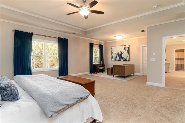 a spacious bedroom with a large bed and a chandelier