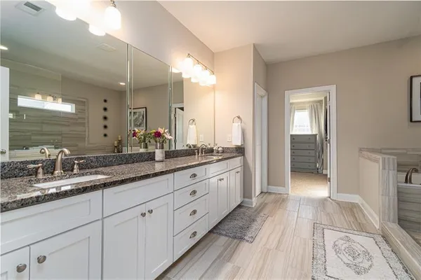 a spacious bathroom with a granite countertop sink a mirror and a