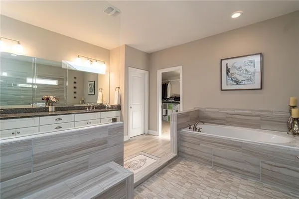 a spacious bathroom with a tub shower and sink