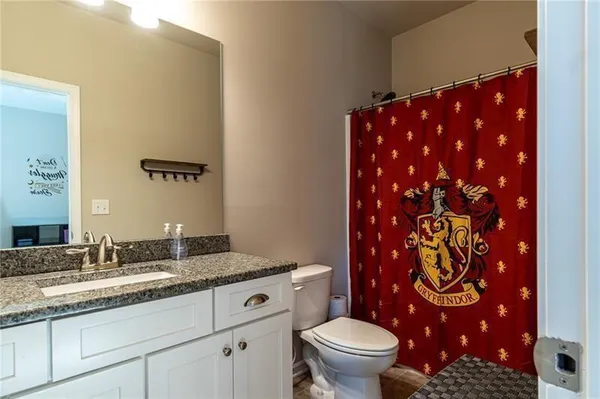 a bathroom with a granite countertop sink a toilet and a mirror