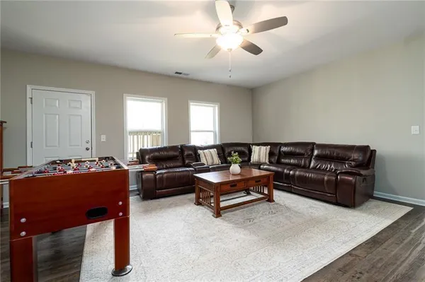 a living room with furniture a chandelier and a piano