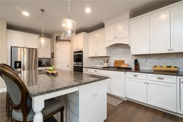 a kitchen with stainless steel appliances granite countertop a sink a stove and refrigerator