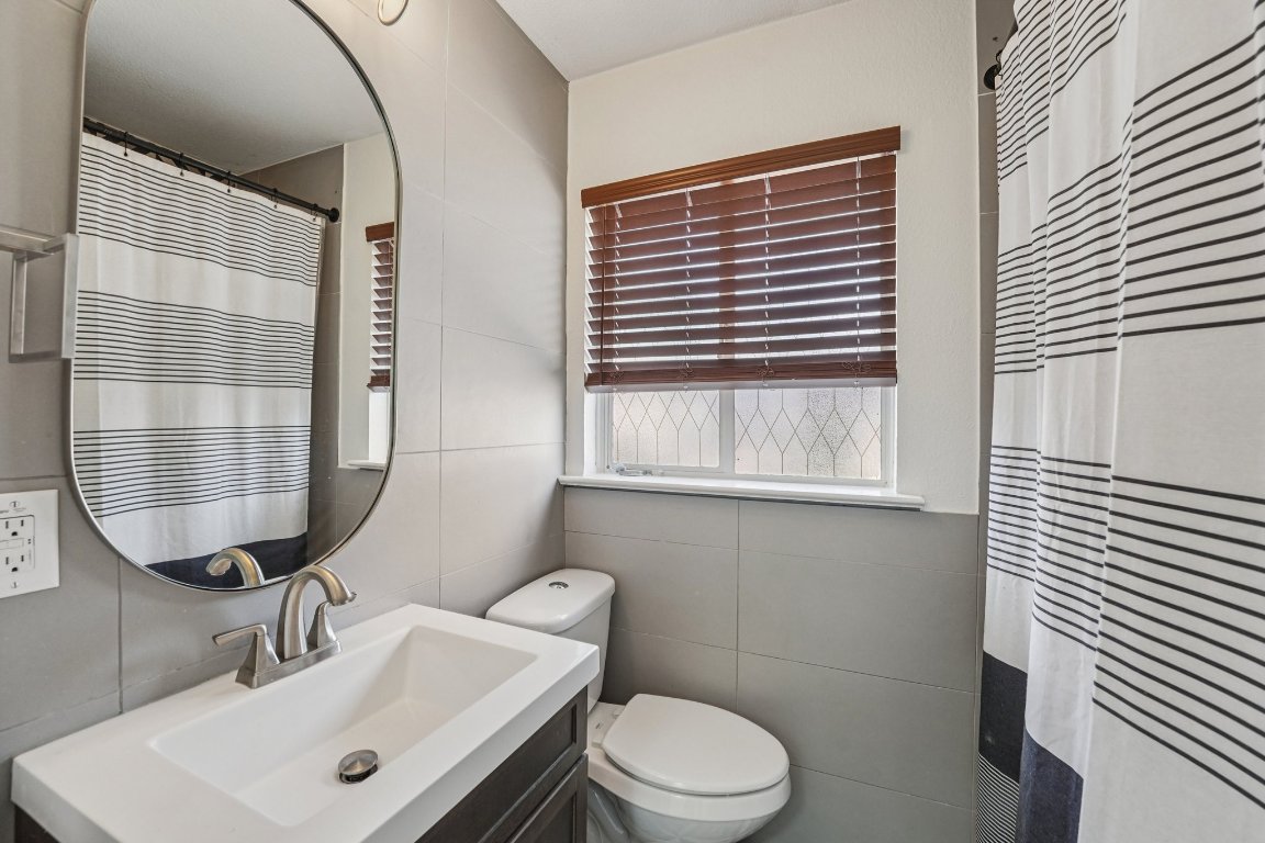 3705 Manorwood Road Austin, TX 78723 - Photo 11 of 16 a bathroom with a sink a toilet and mirror