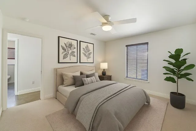 a bedroom with a large bed and a potted plant