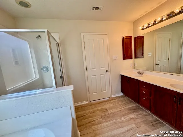 a bathroom with a double vanity sink a mirror and a shower
