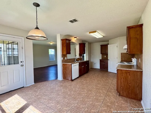 a kitchen with stainless steel appliances granite countertop a stove refrigerator and cabinets