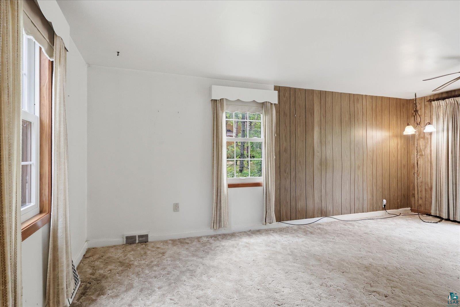 5192 Lavaque Junction Road Hermantown, MN 55811 - Photo 16 of 34 Room featuring a window with an exterior landscape, light wood paneling, and a ceiling-mounted light fixture